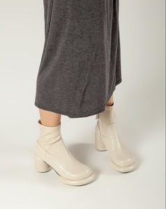 Rounded toe off-white platform boots worn with grey skirt
