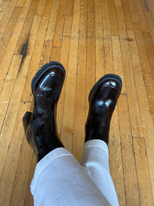 Shiny burgundy ankle boots worn with white pants