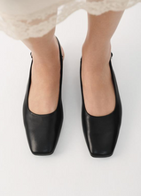 Load image into Gallery viewer, top view of black flats on woman&#39;s feet