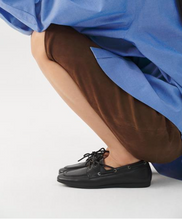 Load image into Gallery viewer, Black leather boat shoes on model with blue shirt and brown skirt