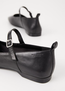 Close up of buckle detail and the heel of black Mary Jane shoes