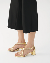 Load image into Gallery viewer, woman wearing black pants with gold strappy sandal