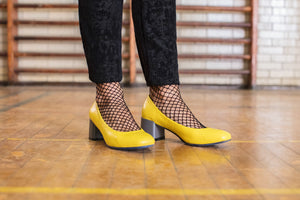 Model wearing Yellow leather pump with chunky grey heel.