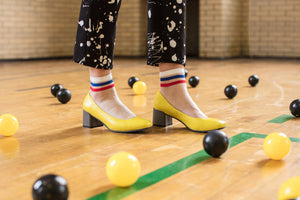 Model wearing Yellow leather pump with chunky grey heel.