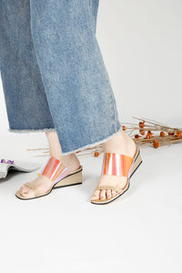 Gold wedge sandals worn with jeans