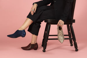 Model holding Tan Snakeskin bootie wearing Blue and Oxblood booties