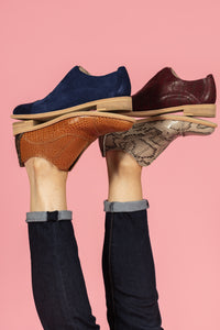 Model wearing Tan snakeskin, Cognac Tan, Navy, and Oxblood leather oxfords