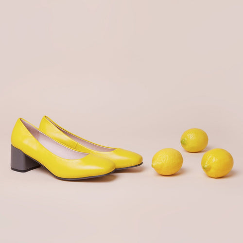 Yellow leather pump with chunky grey heel.