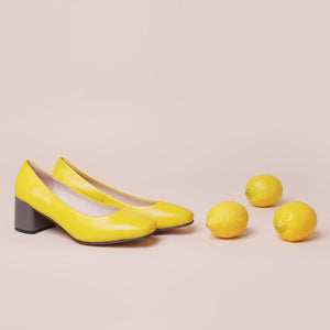 Yellow leather pump with chunky grey heel.