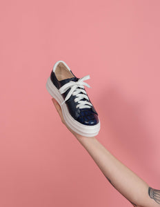 Model holding Navy leather chunky sneaker