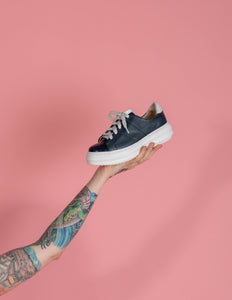 Model holding Navy leather chunky sneaker