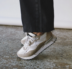 White and beige sneaker worn with black jeans